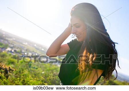 Stock Photo - Young woman in rural setting, laughing. Fotosearch