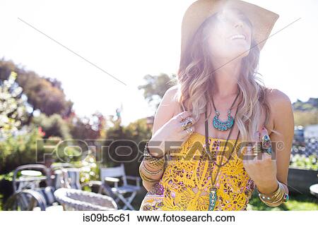 Young woman looking up from sunlit garden View Large Photo Image Stock Image - Young woman looking up from sunlit garden. Fotosearch