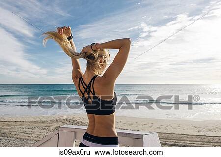 Young woman on lifeguard platform, putting hair up, rear view View Large Photo Image Stock Photograph - Young woman on lifeguard platform, putting hair up, rear view. Fotosearch