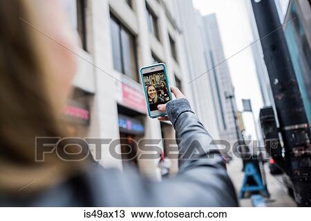 Young woman, outdoors, holding smartphone, on video call, rear view View Large Photo Image Stock Image - Young woman, outdoors, holding smartphone, on video call, rear view. Fotosearch