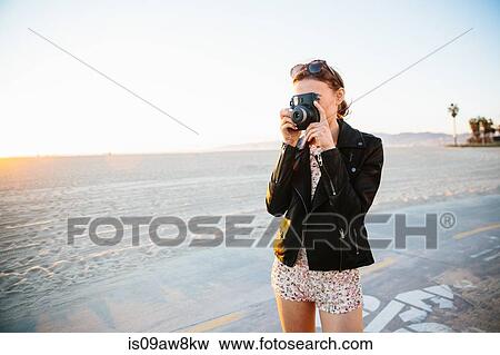 Young woman photographing with instant camera on beach, Venice Beach, California, USA View Large Photo Image Stock Photo - Young woman photographing with instant camera on beach, Venice Beach, California, USA. Fotosearch