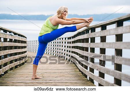 Young woman practicing yoga on wooden pier View Large Photo Image Stock Photo - Young woman practicing yoga on wooden pier. Fotosearch