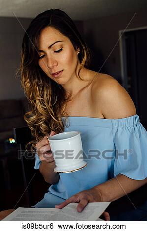Young woman reading book at table View Large Photo Image Stock Photograph - Young woman reading book at table. Fotosearch
