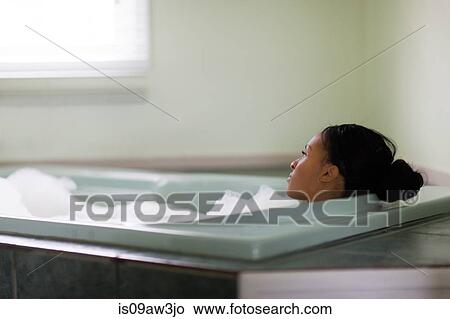Young woman relaxing in bubble bath gazing through window View Large Photo Image Picture - Young woman relaxing in bubble bath gazing through window. Fotosearch