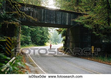 Young woman running along rural road View Large Photo Image Stock Photo - Young woman running along rural road. Fotosearch