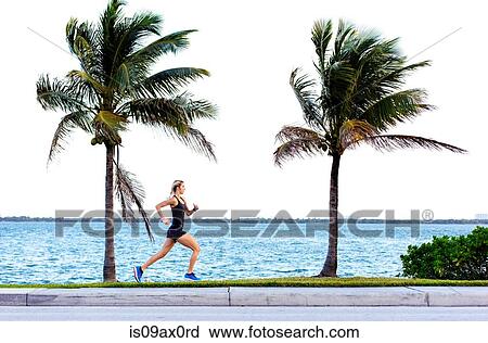 Young woman running near water's edge View Large Photo Image Stock Image - Young woman running near water's edge. Fotosearch