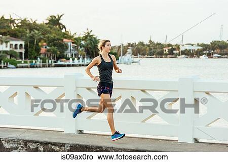 Young woman running outdoors View Large Photo Image Picture - Young woman running outdoors. Fotosearch