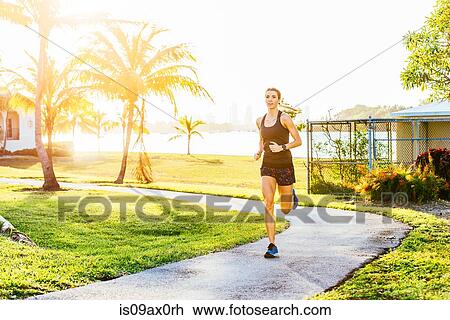Young woman running outdoors View Large Photo Image Stock Image - Young woman running outdoors. Fotosearch