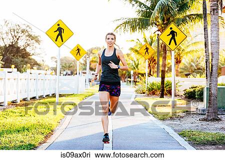 Young woman running outdoors View Large Photo Image Stock Image - Young woman running outdoors. Fotosearch
