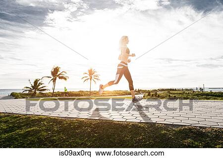 Young woman running outdoors View Large Photo Image Stock Photography - Young woman running outdoors. Fotosearch