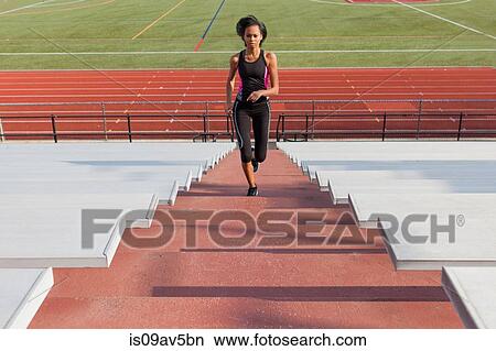 Young woman running up steps at sports track View Large Photo Image Picture - Young woman running up steps at sports track. Fotosearch