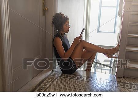 Young woman sitting at top of stairs, using digital tablet View Large Photo Image Stock Image - Young woman sitting at top of stairs, using digital tablet. Fotosearch