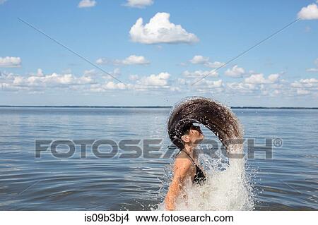 Young woman splashing and throwing back long hair from sea, Santa Rosa Beach, Florida, USA View Large Photo Image Picture - Young woman splashing and throwing back long hair from sea, Santa Rosa Beach, Florida, USA. Fotosearch