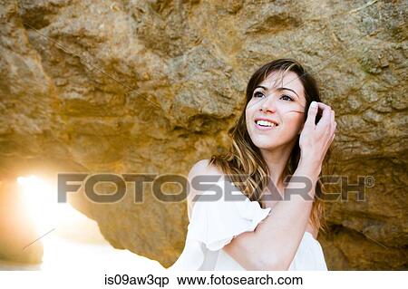 Young woman tidying hair behind rock formation View Large Photo Image Stock Photography - Young woman tidying hair behind rock formation. Fotosearch