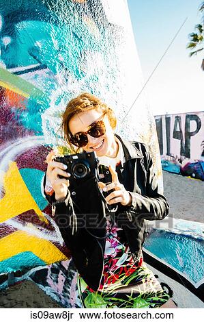 Young woman using digital camera, smiling View Large Photo Image Stock Photography - Young woman using digital camera, smiling. Fotosearch