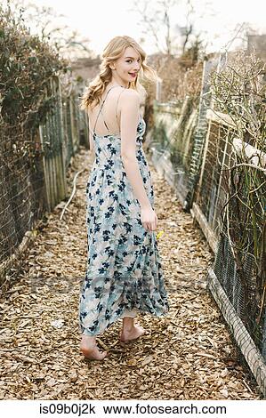 Young woman walking along rural farm pathway, rear view View Large Photo Image Stock Image - Young woman walking along rural farm pathway, rear view. Fotosearch