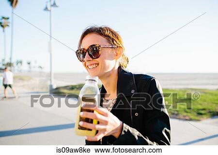 Young woman with fruit juice at coast, Venice Beach, California, USA View Large Photo Image Stock Image - Young woman with fruit juice at coast, Venice Beach, California, USA. Fotosearch