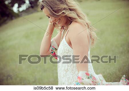 Young woman with long blond hair strolling in field View Large Photo Image Stock Photo - Young woman with long blond hair strolling in field. Fotosearch