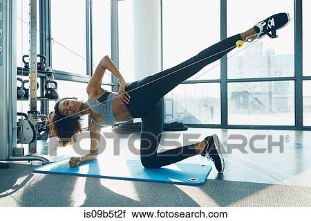 Young woman working out in gym, using gym equipment View Large Photo Image Stock Image - Young woman working out in gym, using gym equipment. Fotosearch