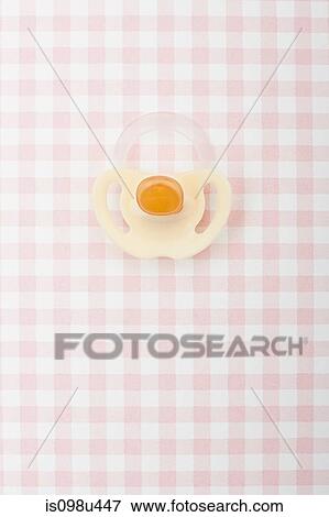 Stock Photo - Pacifier on pink checker pattern. Fotosearch