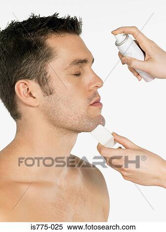 Stock Photography - Man having water sprayed on his face. Fotosearch