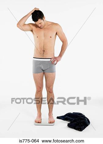 Picture - Man looking at scales. Fotosearch