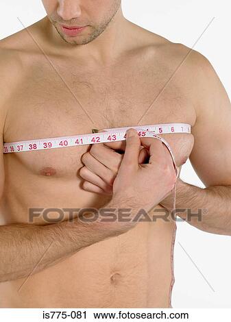 Stock Image - Man measuring his chest. Fotosearch