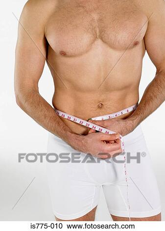 Man measuring his waist View Large Photo Image Stock Image - Man measuring his waist. Fotosearch
