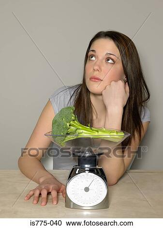 Young woman weighing broccoli View Large Photo Image Stock Image - Young woman weighing broccoli. Fotosearch