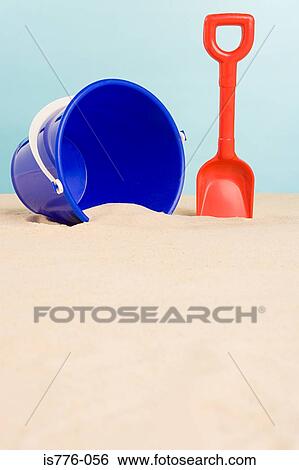 Bucket and spade on beach View Large Photo Image Stock Photograph - Bucket and spade on beach. Fotosearch