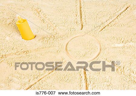 Stock Photo - Suncream and sun drawn in sand. Fotosearch