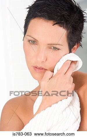 Woman drying her face View Large Photo Image Stock Image - Woman drying her face. Fotosearch