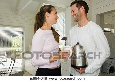 Couple with cup and kettle View Large Photo Image Stock Photo - Couple with cup and kettle. Fotosearch
