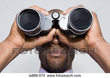 Man looking through binoculars View Large Photo Image Picture - Man looking through binoculars. Fotosearch
