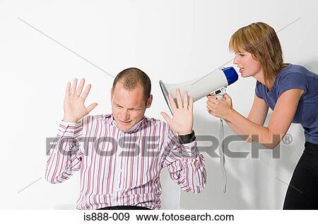 Stock Photo - Man shouting at man through loudspeaker. Fotosearch