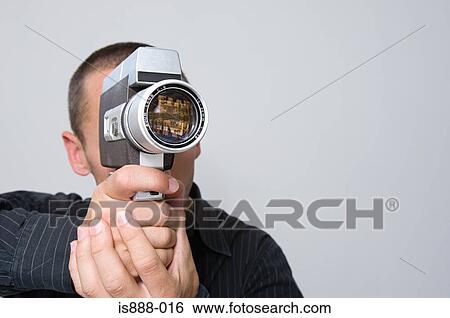 Man using cine camera View Large Photo Image Stock Photograph - Man using cine camera. Fotosearch