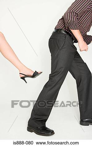 Stock Image - Woman about to kick a man. Fotosearch