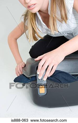 Woman trying to close suitcase View Large Photo Image Stock Image - Woman trying to close suitcase. Fotosearch