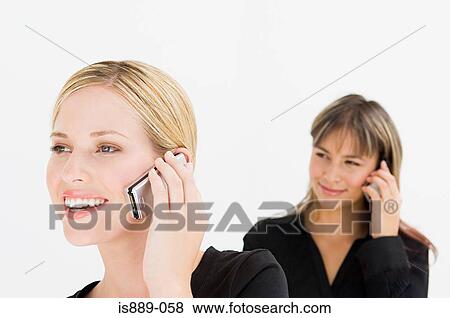 Stock Photo - Businesswomen using cell phones. Fotosearch