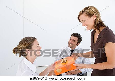 Stock Photograph - Woman giving present to colleague. Fotosearch
