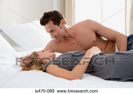 Stock Photo - Couple lying on bed. Fotosearch