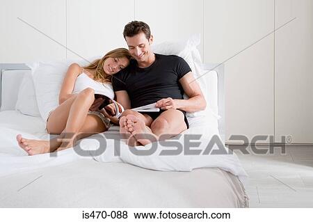 Couple reading a magazine View Large Photo Image Stock Photo - Couple reading a magazine. Fotosearch