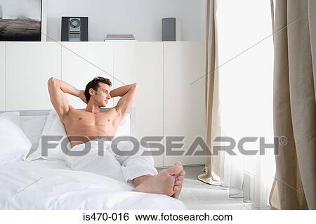 Man relaxing in bedroom View Large Photo Image Stock Photograph - Man relaxing in bedroom. Fotosearch