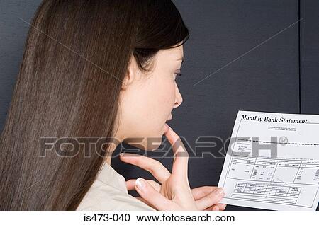 Stock Image - Woman looking at bank statement. Fotosearch