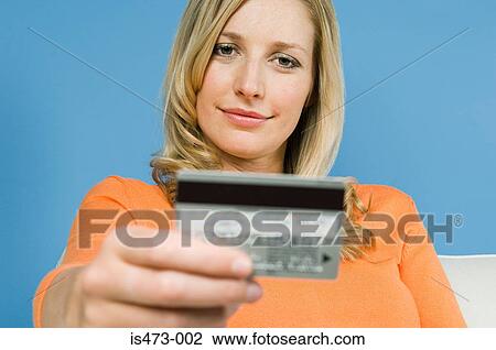 Stock Image - Woman looking at credit card. Fotosearch