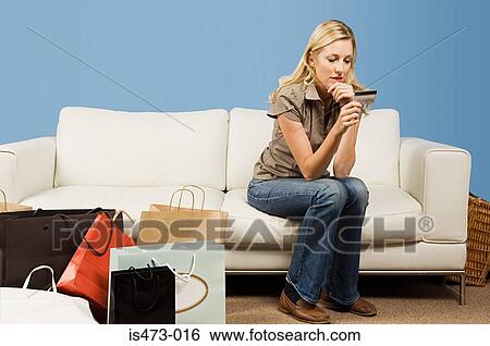 Woman looking at credit card View Large Photo Image Stock Photograph - Woman looking at credit card. Fotosearch