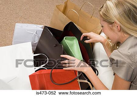 Woman looking in shopping bags View Large Photo Image Stock Image - Woman looking in shopping bags. Fotosearch