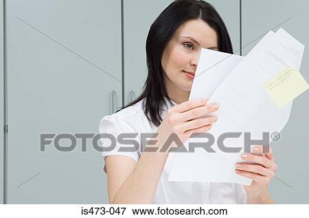 Woman reading paperwork View Large Photo Image Stock Photo - Woman reading paperwork. Fotosearch