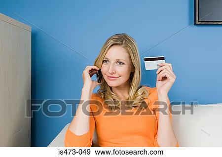 Woman using credit card and cell phone View Large Photo Image Stock Photo - Woman using credit card and cell phone. Fotosearch
