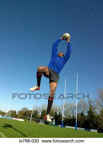 Rugby player catching ball View Large Photo Image Stock Image - Rugby player catching ball. Fotosearch